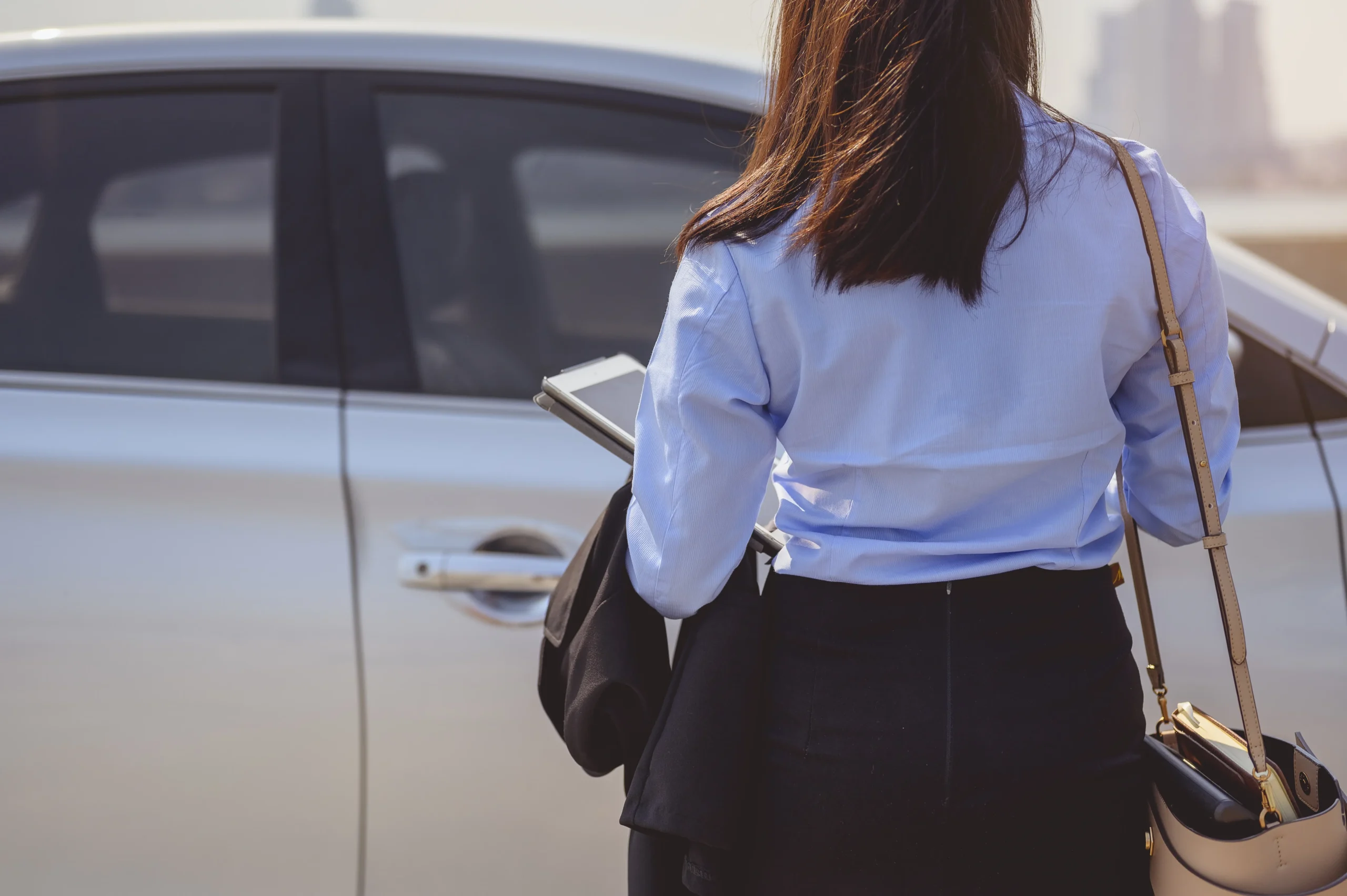 Woman conducting a walkaround check on a grey fleet vehicle