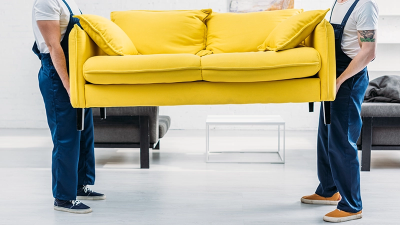 two-men-carrying-a-yellow-sofa