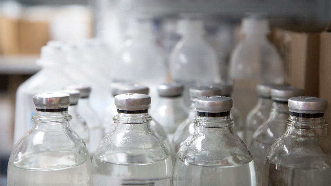 Medical vials, vaccine bottle in storage shelf closeup